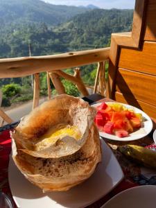 uma sanduíche e um prato de fruta numa mesa em The Dream Inn em Ella