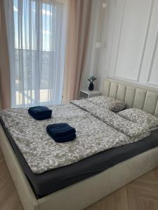 een bed met twee blauwe kussens erop bij Apartament Vulcano Komfort Nowy Ursus in Warschau