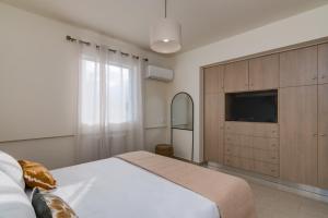 a bedroom with a large bed and a television at Oikies Luxury Apartments with private free parking area in Agios Nikolaos