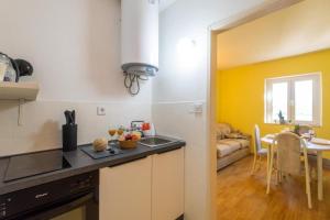 a kitchen with a sink and a table in a room at Diamond Sea - Vacation House with Private Parking and a Big Terrace over the Sea in Dubrovnik
