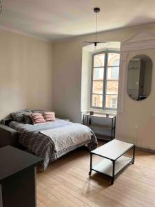 1 dormitorio con cama, mesa y ventana en Chez Bouch, en Montauban