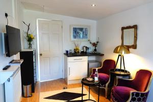 a kitchen with a table and two chairs in a room at Rye Treat in Rye