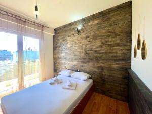 sypialnia z dużym łóżkiem i drewnianą ścianą w obiekcie Woodstay Apartments w mieście Orestiada