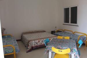 a room with two beds and two tables and a window at Gioiosa Marea Appartamento per 4 con vista sulle Eolie Casa Spisidda "Panarea" in Gioiosa Marea