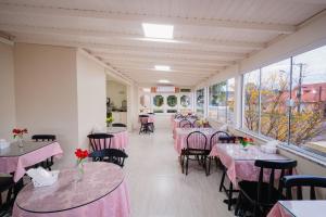 um restaurante com mesas e cadeiras com toalhas de mesa cor-de-rosa em Hotel Cabanas Alto Da Serra em Canela