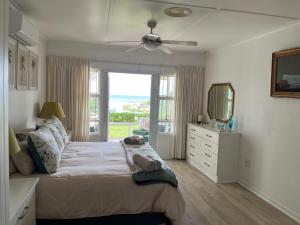 a bedroom with a bed with a dresser and a mirror at The Estuary Country Estate, Villa "Once Upon A Tide" in Port Edward