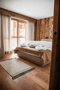 um quarto com uma cama e uma grande janela em Exzelent Residence em Anterselva di Mezzo