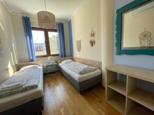 a small room with two beds and a mirror at Klimatyzowany apartament z basenem i garażem Willa 4 Pory Roku in Jastrzębia Góra