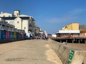 a boardwalk with buildings and people walking on it at Gorgeous Spacious Apartment with Sea View in Walton-on-the-Naze