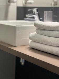 a stack of towels on a counter next to a sink at Apartament 25 Czarna Góra nr 5 Ischgl in Sienna