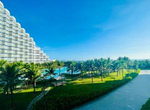 uma vista para um resort com palmeiras e um rio em The Oceanfront Apartment At Cam Ranh em Cam Ranh
