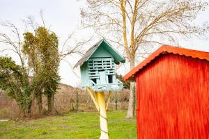 a birdhouse on a pole next to a redshed at Tias Shelale Otel in Sile