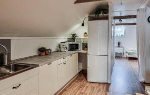 a kitchen with white cabinets and a white refrigerator at Awesome Apartment In Ljungskile With Wifi in Ljungskile