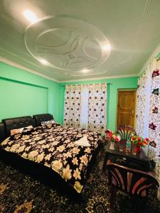 una camera da letto con letto, pareti verdi e soffitto di Fab Ocean Guest House a Tangmarg