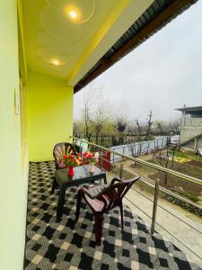 een patio met een tafel en stoelen op een balkon bij Fab Ocean Guest House in Tangmarg