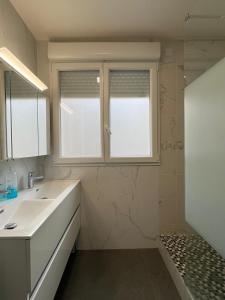 La salle de bains est pourvue d'un lavabo et d'une fenêtre. dans l'établissement location 3 chambres spacieuses dans appartment 2 mn RER Bussy Saint georges, à Bussy-Saint-Georges
