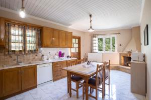 a kitchen with a table and chairs in a room at Elena’s House Sivota Lefkadas in Sivota +5 photos