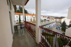 uma varanda com uma mesa e vista para a cidade em Gouveia Vintage House em Gouveia