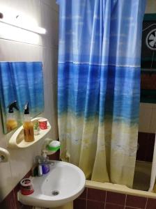a bathroom with a sink and a shower curtain at Masat El Sharjah for men in Sharjah
