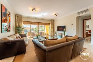 ein Wohnzimmer mit zwei Sofas und einem Tisch in der Unterkunft ViVi Homes - Casa Duque Pool, Terrace & Golf in Alhaurín de la Torre