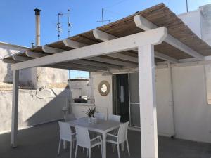 a wooden pergola on a patio with a table and chairs at Attico Belvedere in Gallipoli