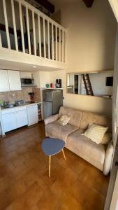 ein Wohnzimmer mit einem Sofa und einer Küche in der Unterkunft T1 bis vue mer 4 personnes piscine ouvert toute l année in Bandol