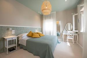 a bedroom with a bed and a table and a mirror at Hotel Atlantica in Cesenatico