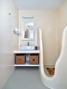 La salle de bains est pourvue d'un lavabo et d'un miroir. dans l'établissement Cordelia Villa, à Psarrou