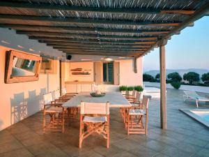 une salle à manger avec une table et des chaises sur une terrasse dans l'établissement Cordelia Villa, à Psarrou