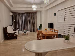 uma sala de estar com uma mesa e uma sala de jantar em Cozzzy hut Riverbank Suites Kuching with spectacular River view em Kuching