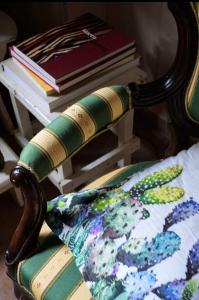 una silla con una almohada y una pila de libros en Les Maisons des Fleurs /IL NIDO DELLE CIVETTE, en Canossa