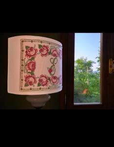 una lámpara con un patrón de flores en la parte posterior de la misma en Les Maisons des Fleurs /IL NIDO DELLE CIVETTE, en Canossa