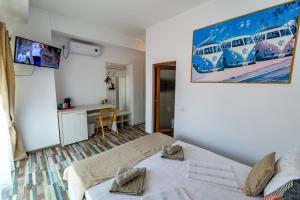 a bedroom with a bed and a large painting on the wall at Casa Amelie Mangalia in Mangalia