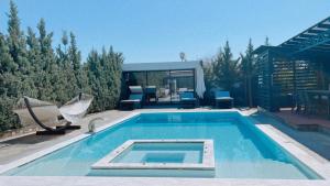 uma piscina com duas cadeiras e uma casa em One Bedroom Pool House by Olivujoj em Anavissos