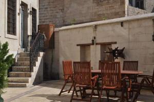 Une table et des chaises en bois sont disponibles sur la terrasse. dans l'établissement Hıdıroğlu Konağı Butik Otel, à Gaziantep