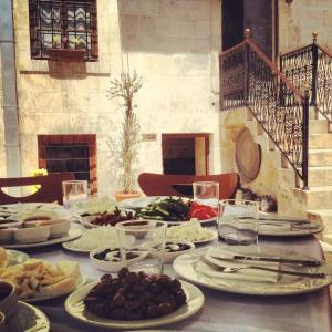 une table avec des assiettes de nourriture au-dessus dans l'établissement Hıdıroğlu Konağı Butik Otel, à Gaziantep