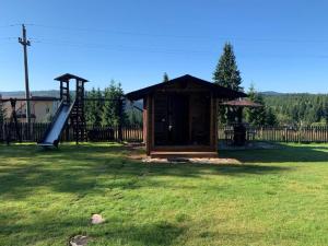 a small cabin with a slide and a playground at Pensiunea Vis Alpin Belis in Beliş
