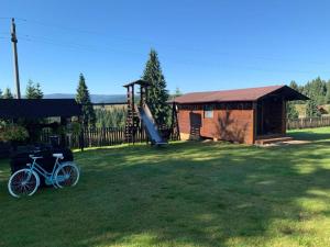 a bike parked in a yard next to a playground at Pensiunea Vis Alpin Belis in Beliş