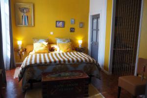 Chambres d'Hôtes Le relais des marmottes في Lagnes: غرفة نوم بسرير بجدران صفراء