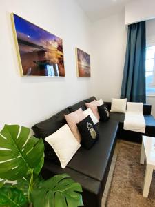 sala de estar con sofá negro con almohadas en Apartamento en C/ León y Castillo (C/ Real) Centro de Arrecife, en Arrecife