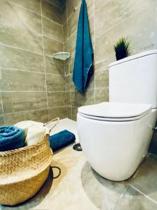 - Baño con aseo y cesta de toallas en Apartamento en C/ León y Castillo (C/ Real) Centro de Arrecife, en Arrecife