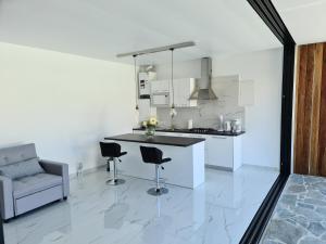 een keuken met een aanrecht en stoelen in een kamer bij One Bedroom Pool House by Olivujoj in Anavissos