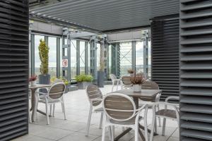 un patio con mesas, sillas y ventanas en Apartamenty Towarowa Poznań, en Poznan