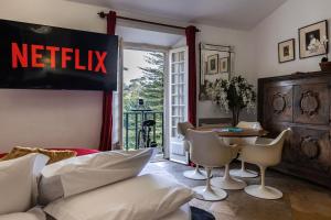 a living room with a netflix sign on the wall at Sintra WOW - Unique double Smart Room in 17th century Palace! Hot tub, Snooker, BBQ, PS5, Sauna, Gym in Sintra