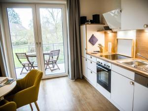 uma cozinha com mesa e cadeiras e uma varanda em Wide Luzin Modern Retreat em Amtshof