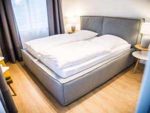 uma cama com lençóis brancos num quarto em Wide Luzin Modern Retreat em Amtshof