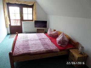 um quarto com uma cama com lençóis e almofadas vermelhas em Sachon Modern Retreat em Dürrwicknitz