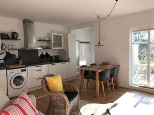 een woonkamer met een keuken en een tafel met stoelen bij Bosau in the Sweden House in Bosau