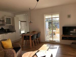 een woonkamer met een tafel en stoelen en een keuken bij Bosau in the Sweden House in Bosau
