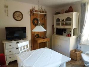 a living room with a table and a tv at Dollhouse Modern retreat in Wiesmoor